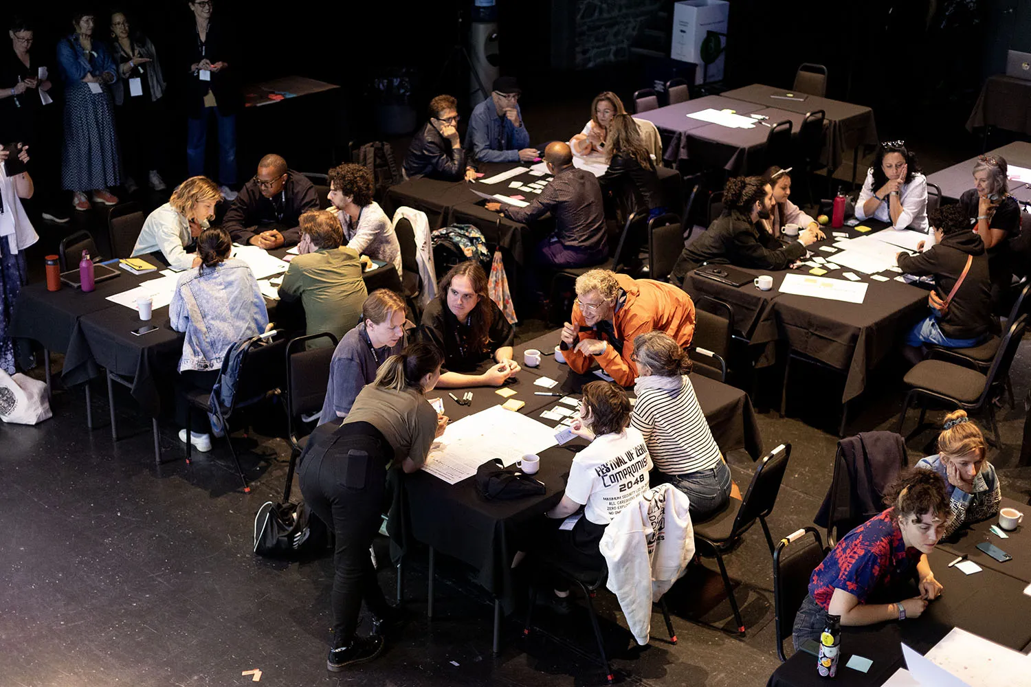 People gathered at different tables working at the Mutek Conference