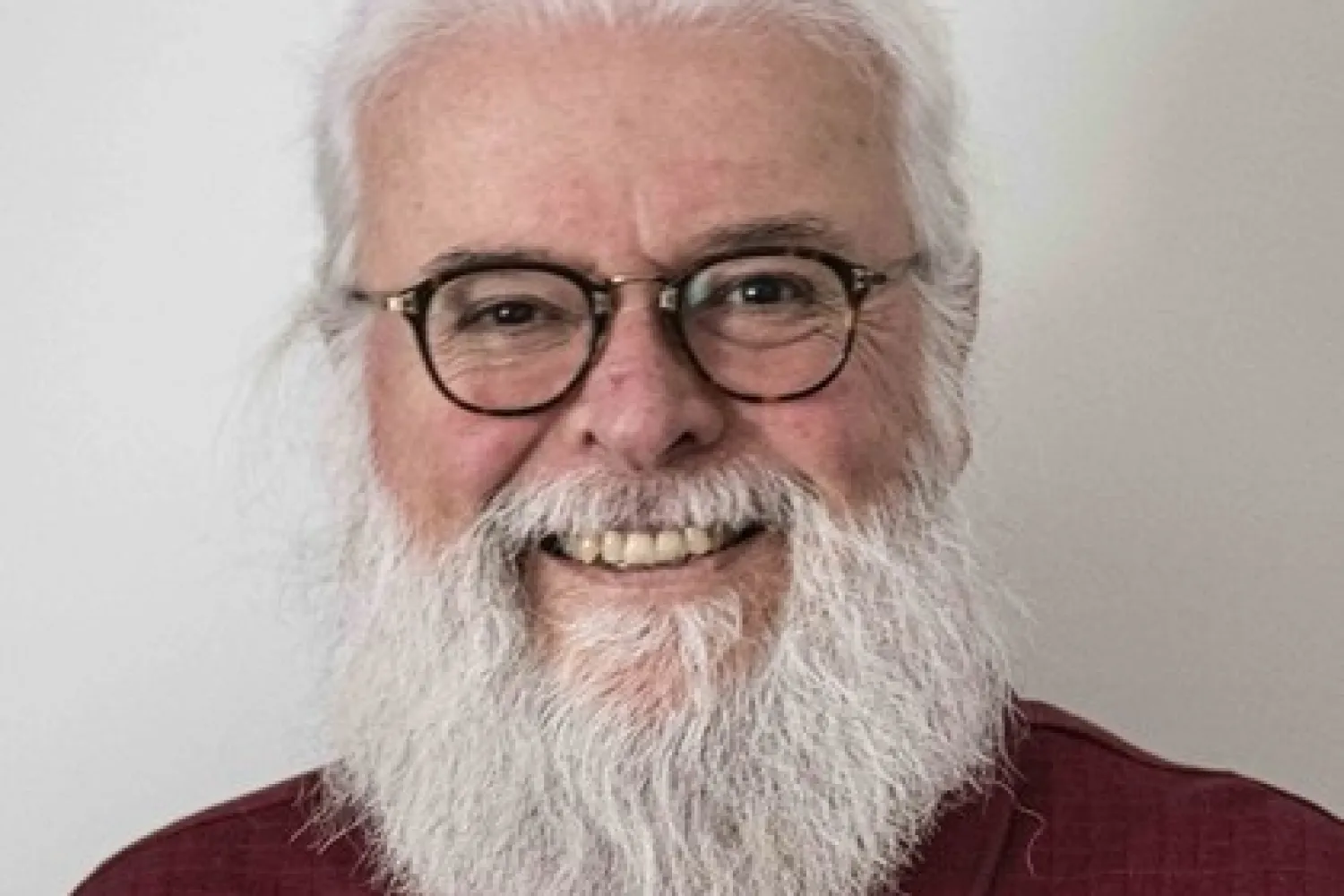 Photo of man with white hair and white beard wearing glasses