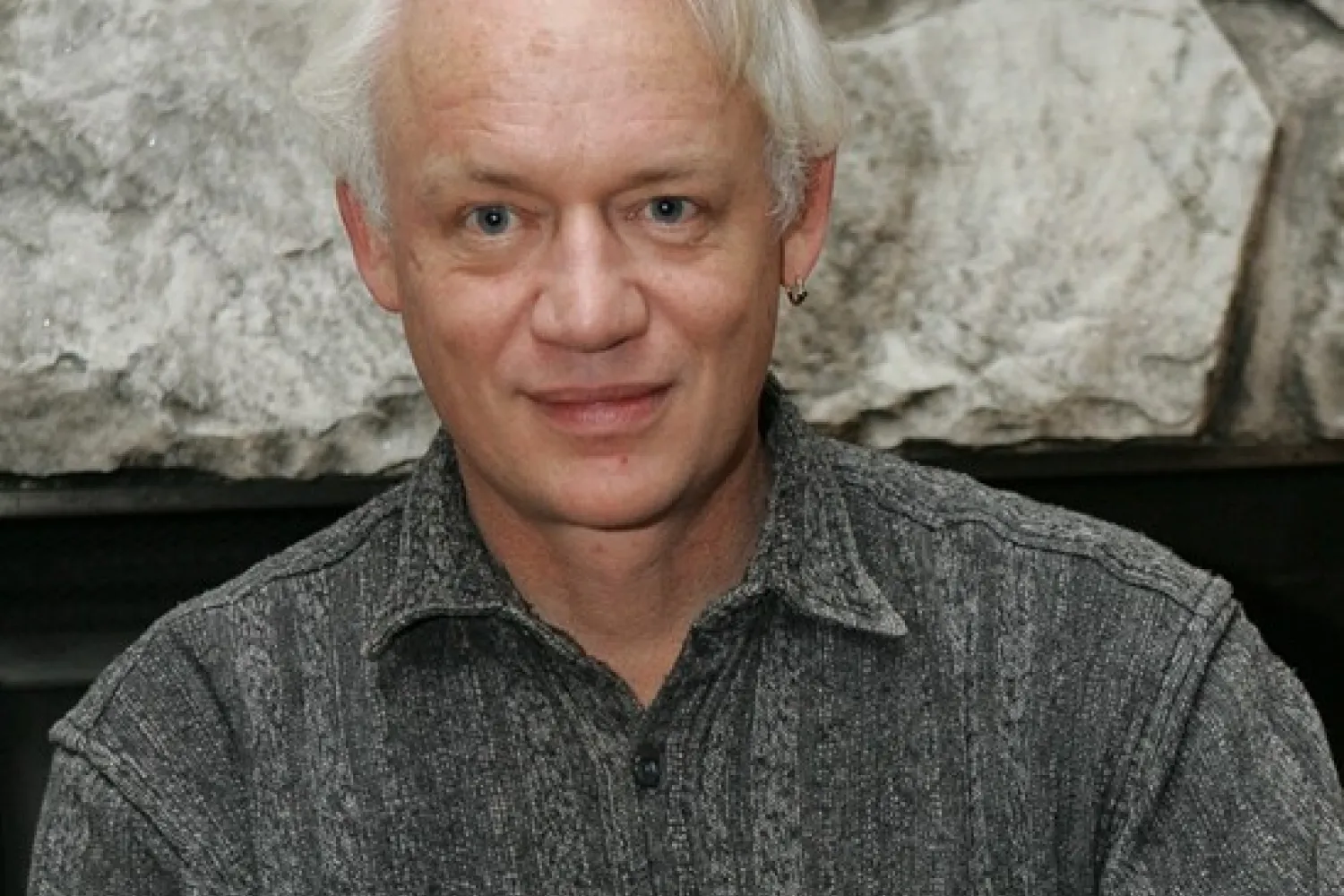 Photo of man with blue eyes and white hair wearing patterned shirt