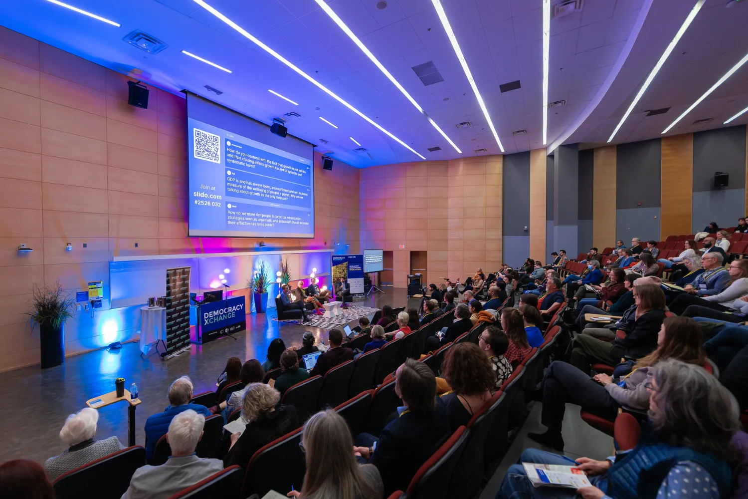 The audience looks on at the stage at DXC24