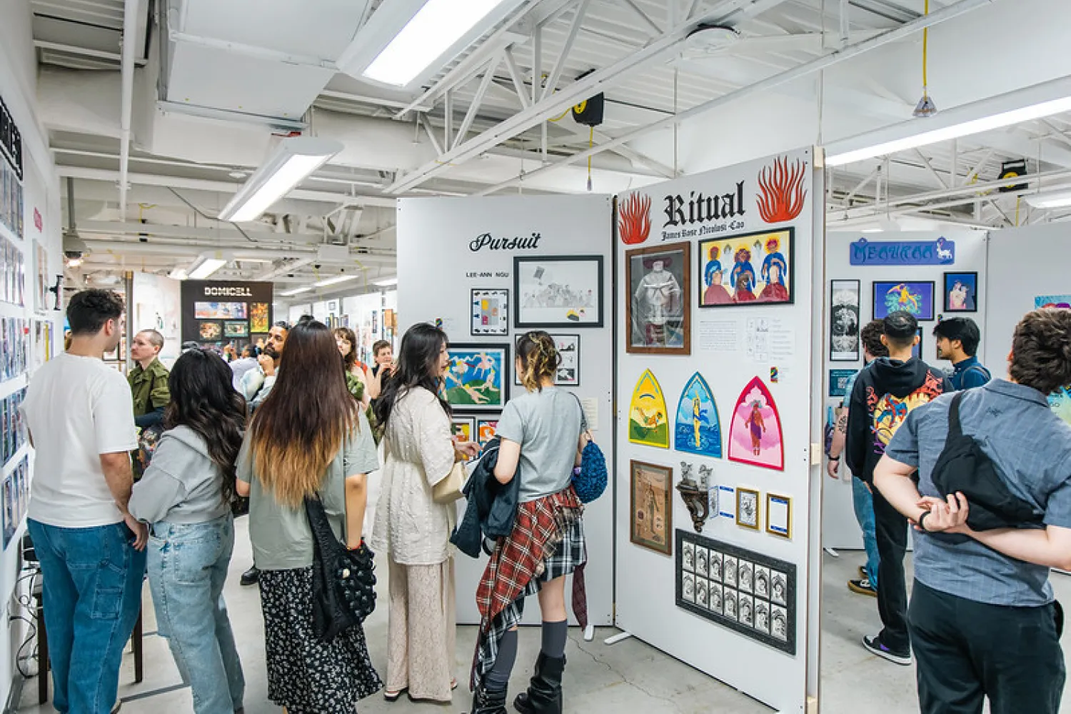 Group of people walking around GradEx 110, seeing illustrations on plinths