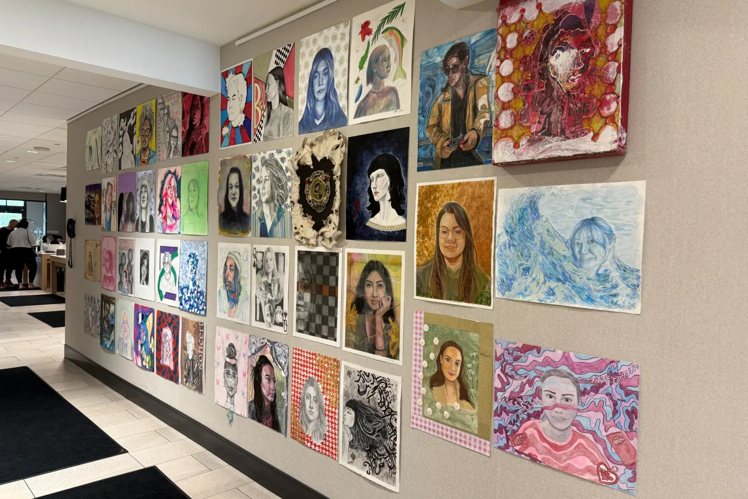 Colourful portraits displayed on a wall. 