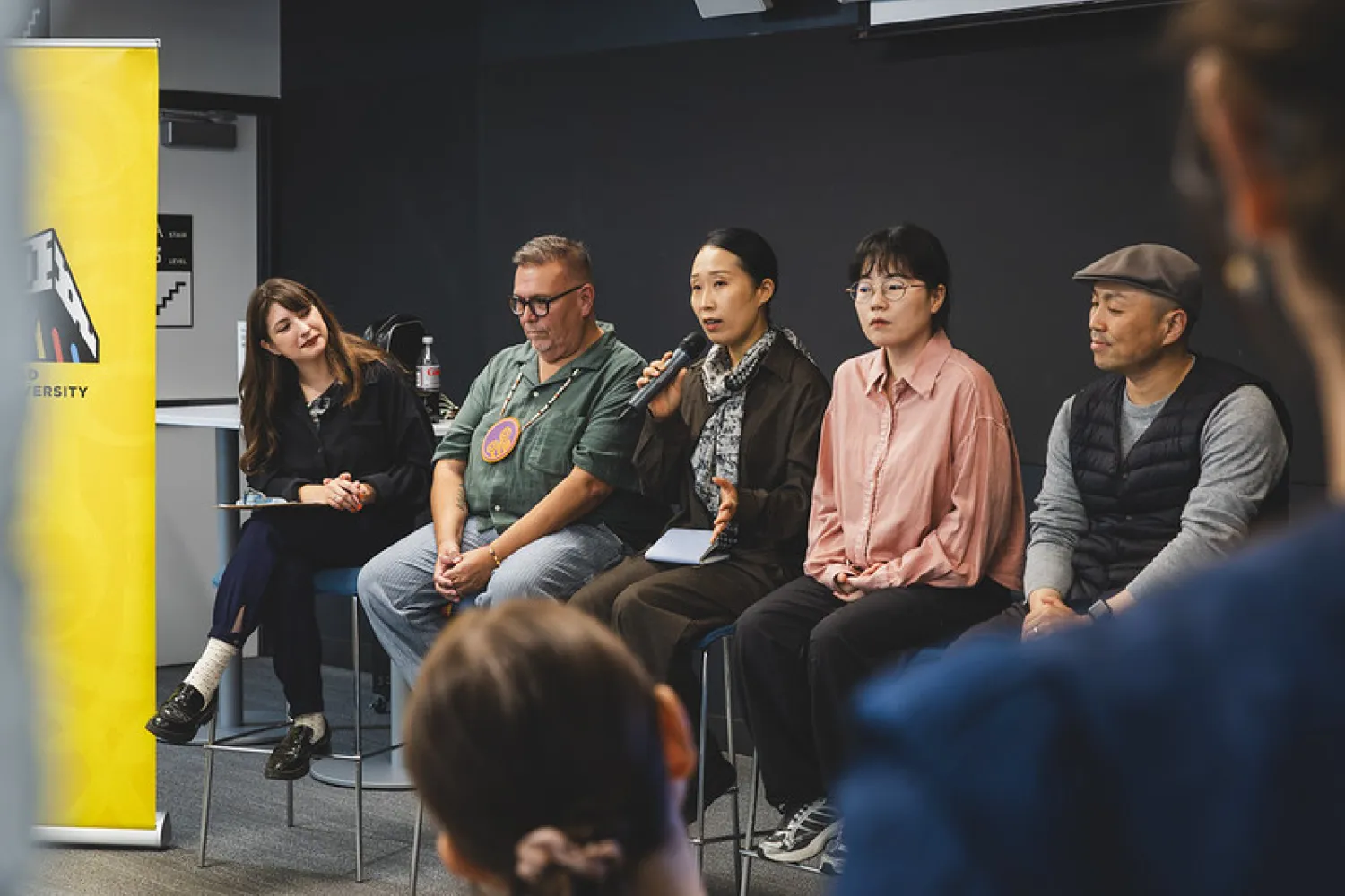 Panel of five people on a stage