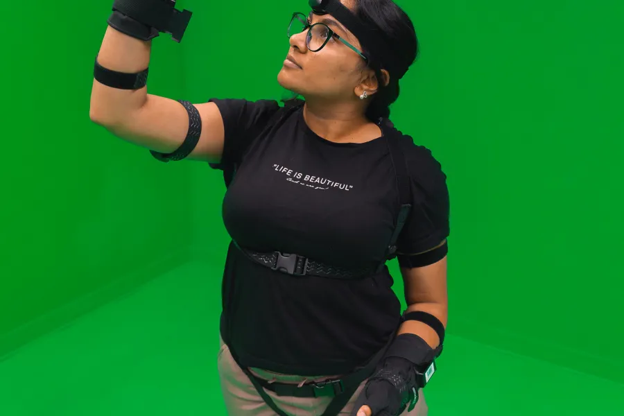 A student wearing a motion capture suit on a green background.
