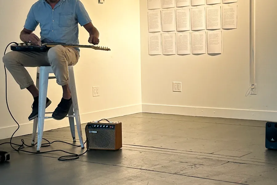 Man playing a guitar in an art gallery