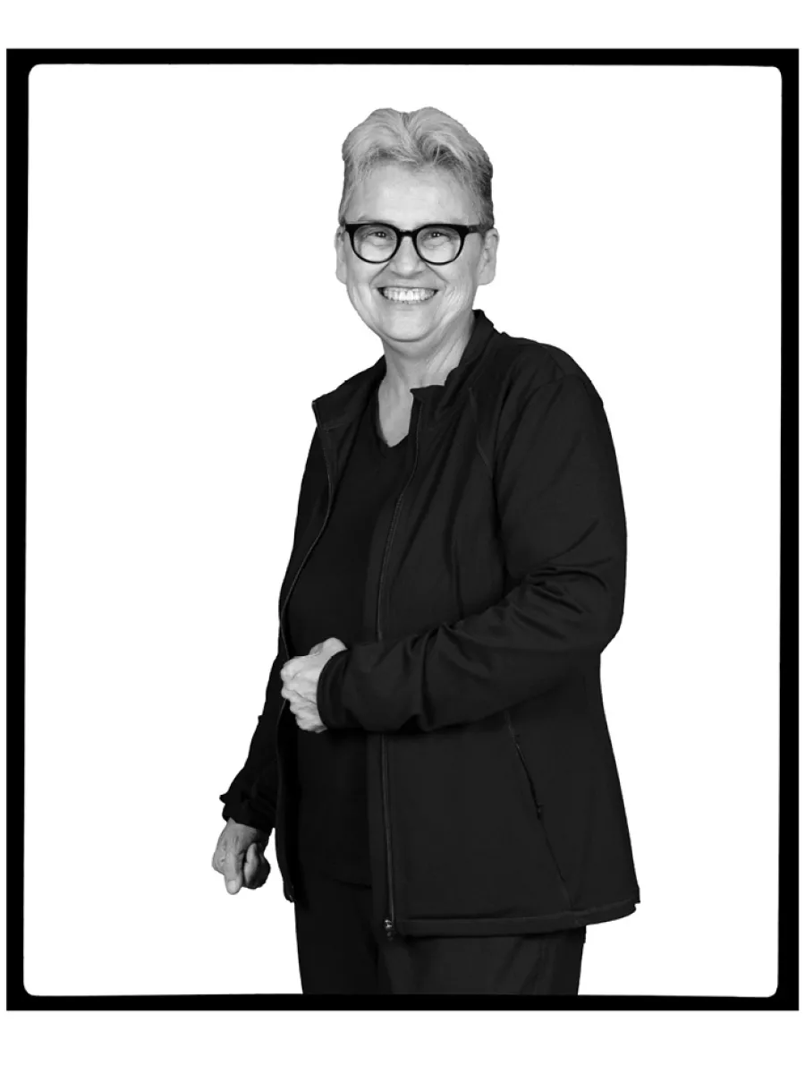 A woman with short black hair and wearing eye glasses with black t-shirt and black jacket