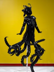 Installation view, Ekow Nimako, Maame Wata, 2023, 64 x 40 x 45 in, LEGO®, metal armature. Photo by Em Moor. Black sculpture in front of yellow wall.