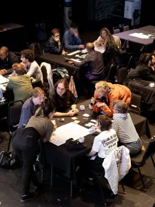People gathered at different tables working at the Mutek Conference
