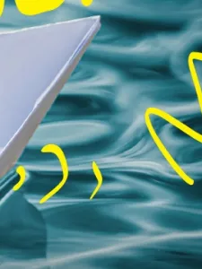 paper boat closeup on water with yellow accents