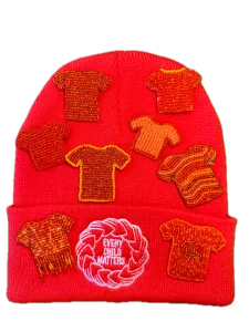 Orange Shirt Day pins resting on an Orange Shirt Day toque