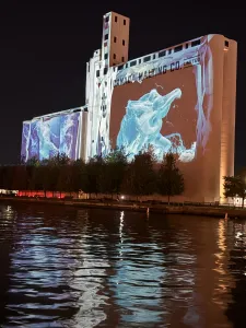 A photo of the Canada Malting Silos with a large-scale projection mapping that looks like water cascading down the building.