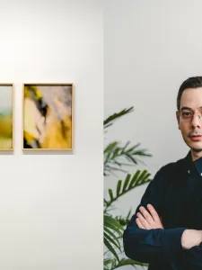On the right, a headshot of Erdem Tasdelen, on the left, documentation of an artwork by him: two blurry images framed and hung on a gallery wall. 