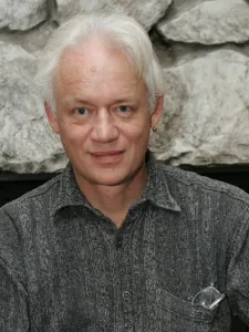 Photo of man with blue eyes and white hair wearing patterned shirt
