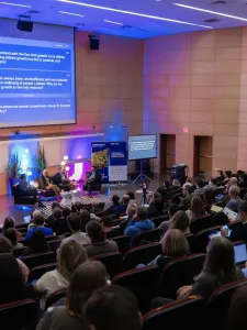 Audience members sitting in an auditorium at a presentation. 