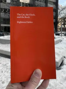 Holding bright orange book to cover the public artwork