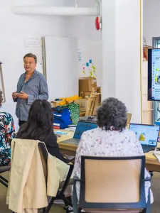 People in a research lab attending a presentation led by two faculty members.