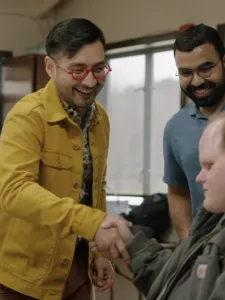 Four men, two are standing up and two are sitting. On the left (standing) is Patrick Burton; on the right (standing) is Aaditya Vaze.