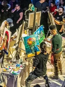 An illustration of a crowd of people watching others create paintings