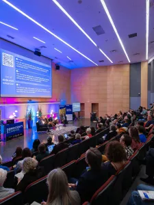 The audience looks on at the stage at DXC24