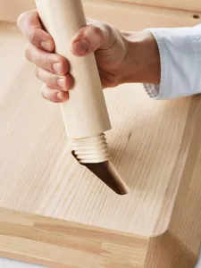 Person inserting a table leg into a flat packed table top