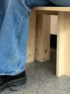 Person sitting on a wooden stool