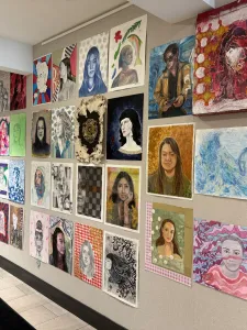 Colourful portraits displayed on a wall. 