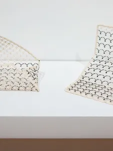 Image of two knotted paper sculptures, left looks like wallet, right looks like open wallet