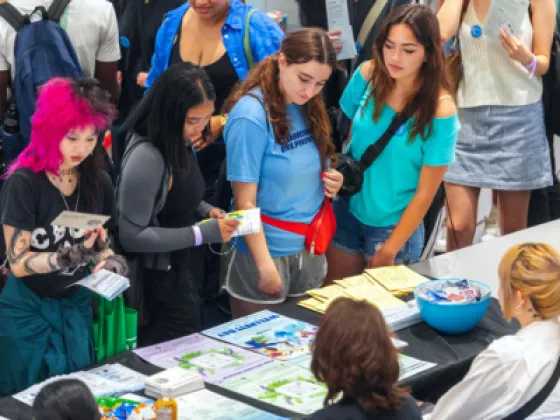 group of students at an event fair table