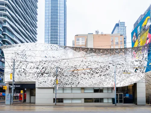 Facade of the Rosalie Sharp Pavillion featuring a large metal scrim with intricate pattern