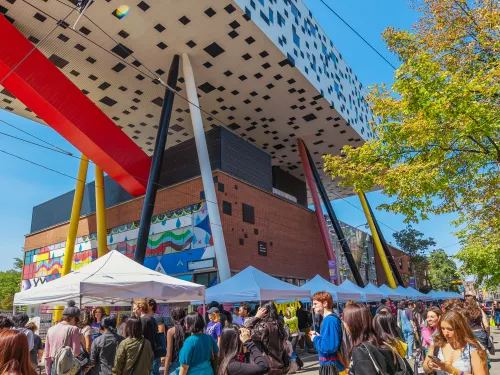 Welcome Day on McCaul St with people visiting booths and the Sharp Centre in the background.