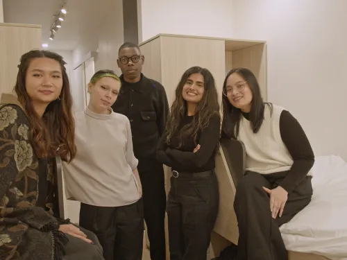 Design students standing in experimental housing unit
