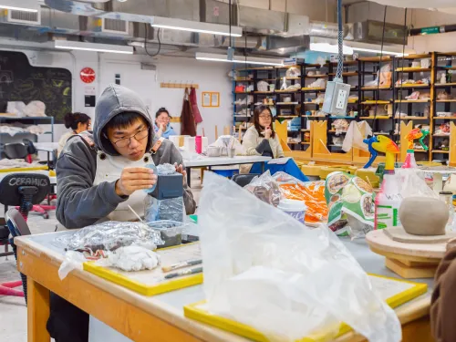 Student working clay in a studio