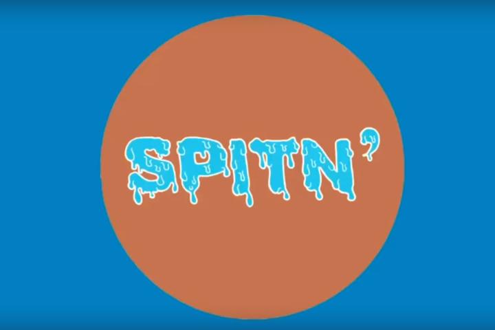 An image of an orange circle on a blue background. Inside the circle is the text "spiting".