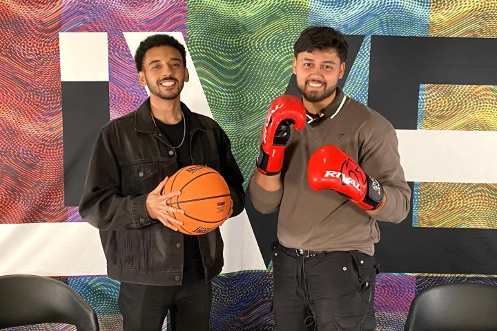 Two people one in front of a background with LIVE written on it one holding a basketball the other holding Yellowgloves