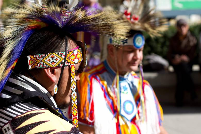 Two Indigenous members wearing regalia