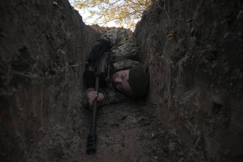 Image of soldier hiding in a narrow trench.