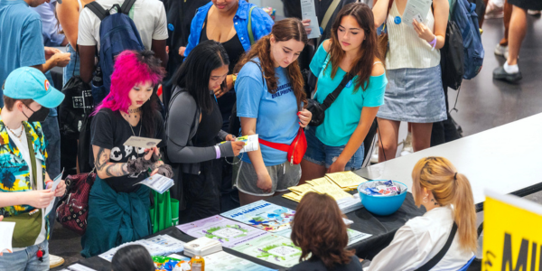 group of students at an event fair table