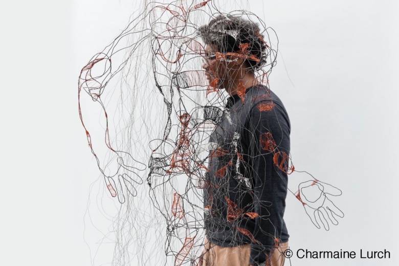 Image of a student interacting with wire-frame art piece by Charmaine Lurch