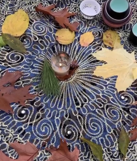 a candle lit in the middle surrounded by tree leaves
