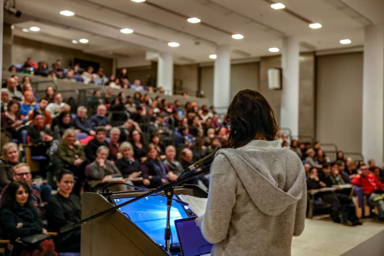 Woman at a podium facing an audience