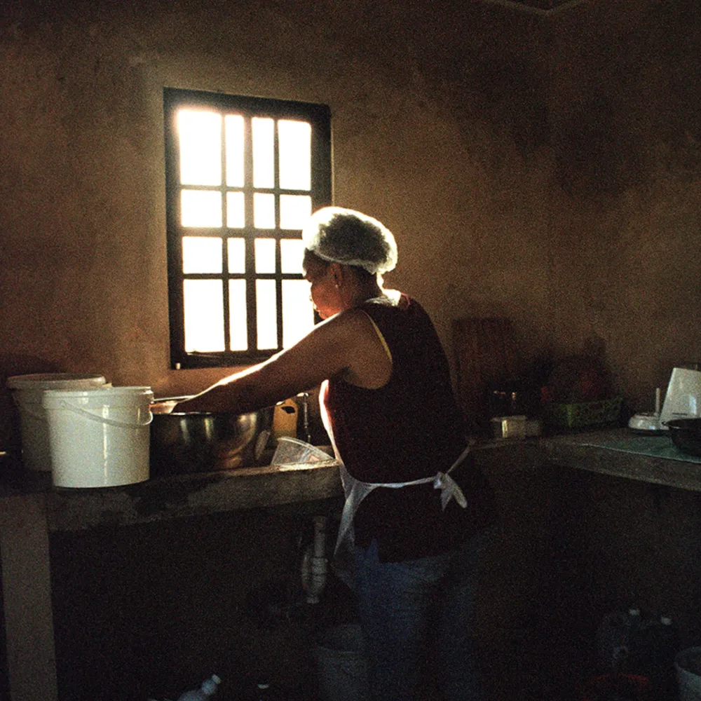 Person washing dishes in dramatic low light