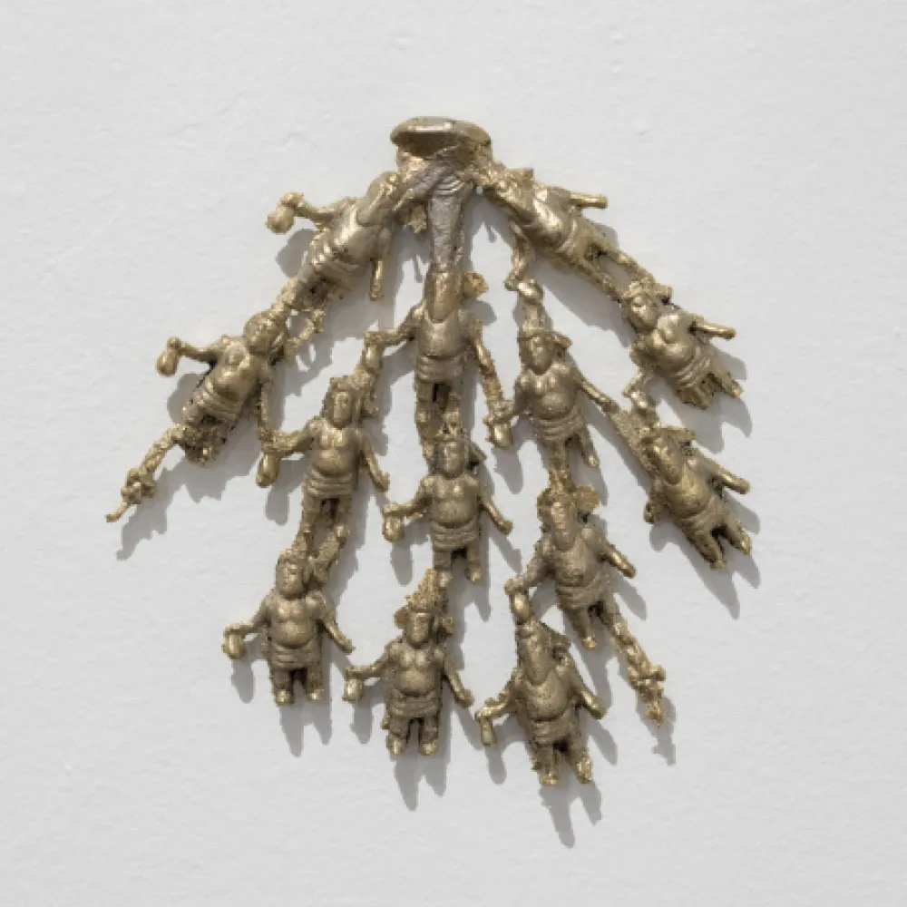 Metal sculpture of small figures attached at the head