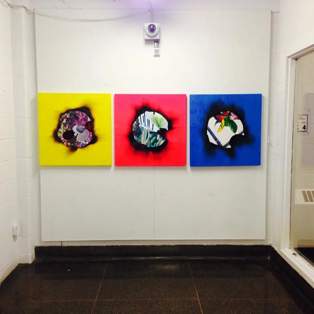 Three paintings on a white gallery wall